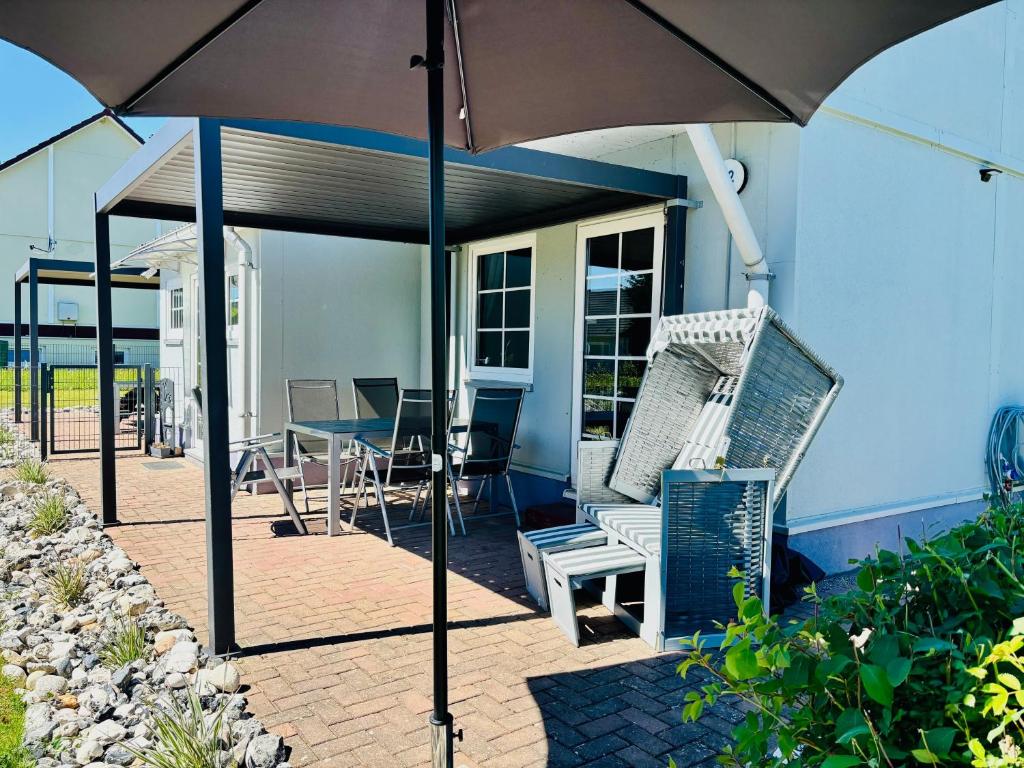 a patio with a table and chairs and an umbrella at Ostsee Ferienhaus Usedom Familie Stopp Haus 22 in Lütow