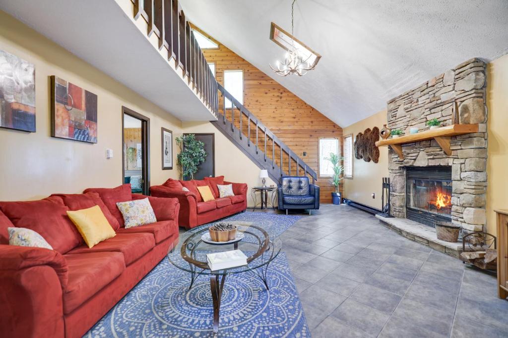 a living room with a red couch and a fireplace at Chalet renovated Near Casino, Camelback , Kalahari 4bdrms firepit hot tub game room in Tobyhanna