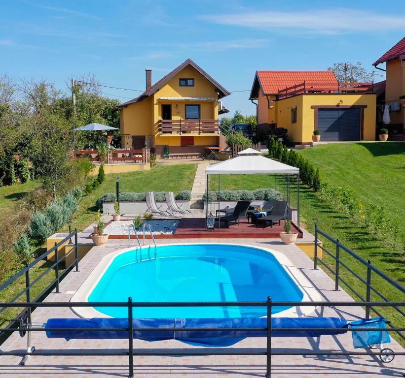 a house with a swimming pool in front of a house at Lily's Rural House in Jarki Horvatićevi