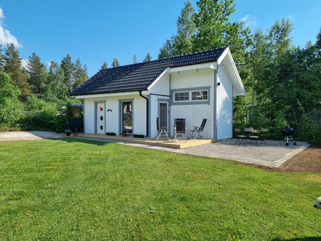 a small white cottage with a large yard at Attefallshuset Toftahöjden 7 in Växjö