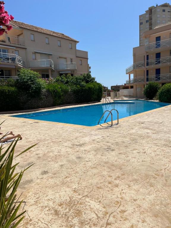 a swimming pool in the middle of a building at Maison T3 avec petit jardin in Valras-Plage