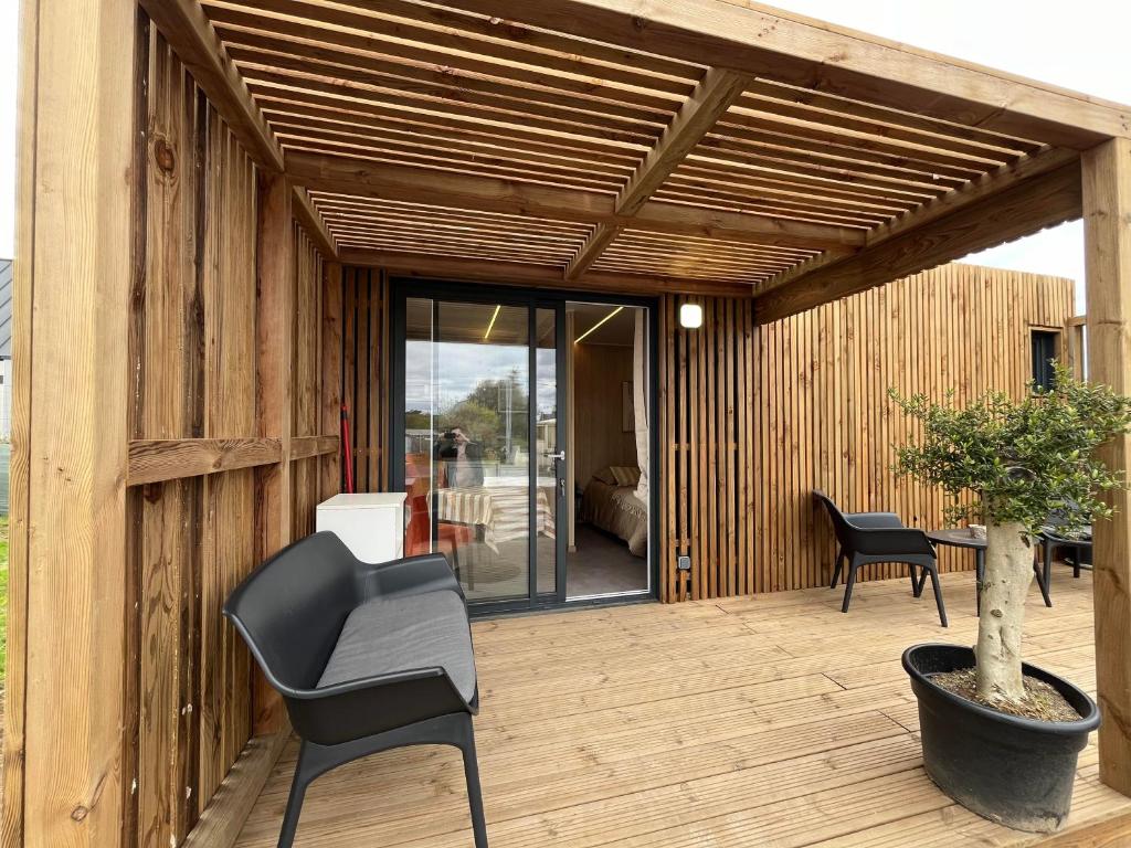 un patio de madera con una silla y una mesa en Green Lodge, en Perros-Guirec
