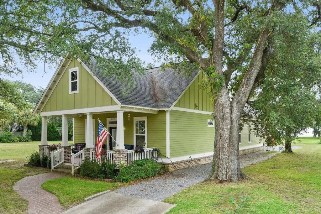 a green house with a flag on the porch at Ocean View-3 Bdrm Plus Mother-In-Law Suite - E-bikes in Gulfport