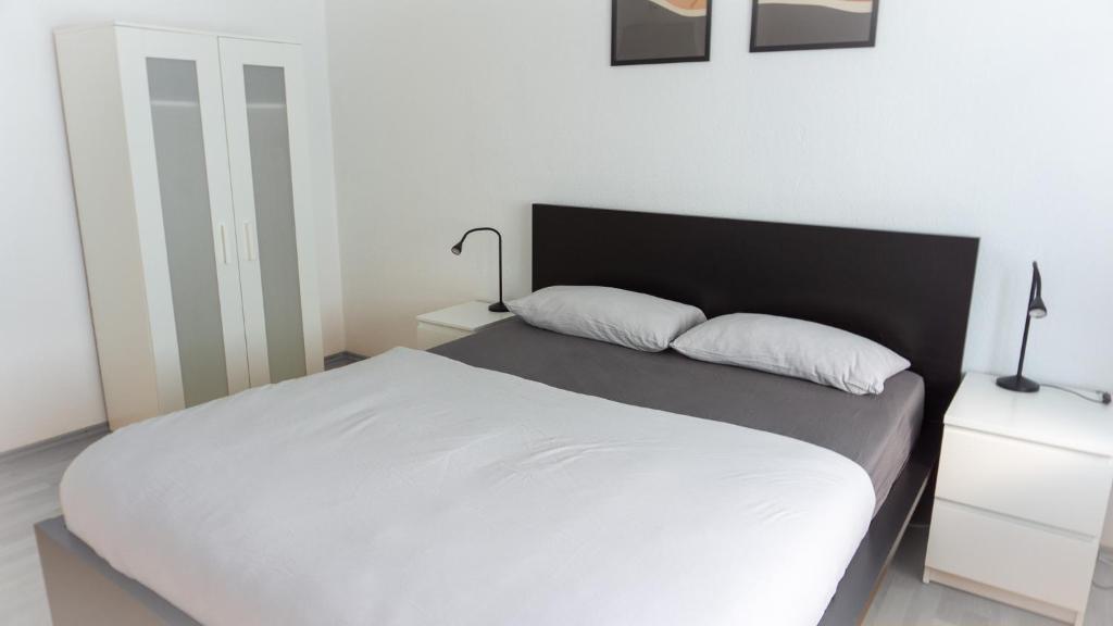 een bed met twee kussens in een slaapkamer bij CENTRAL Apartment Hannover - Good & calm location - Contactless Check-in in Hannover