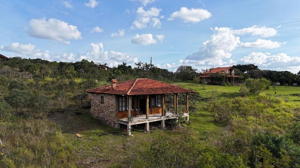 un pequeño edificio en un campo con una casa en Chalés Vila Carrancas - Unidade Serra, en Carrancas