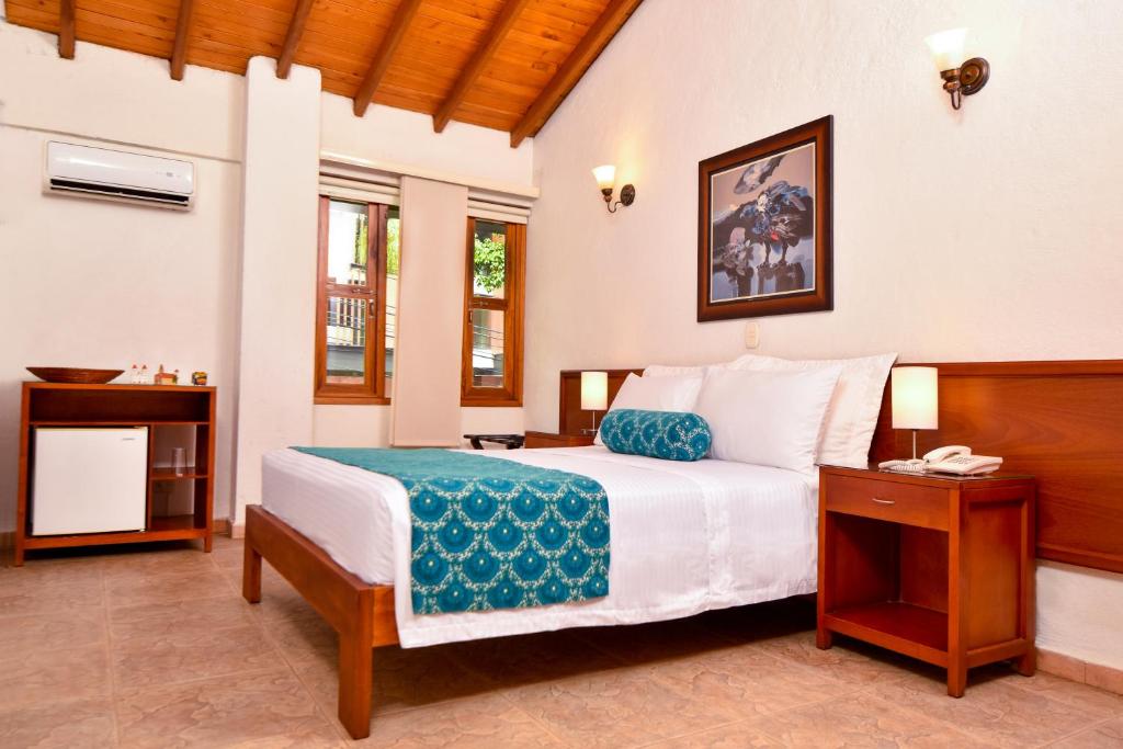 a bedroom with a bed with a telephone in it at La Campana Hotel Boutique in Medellín