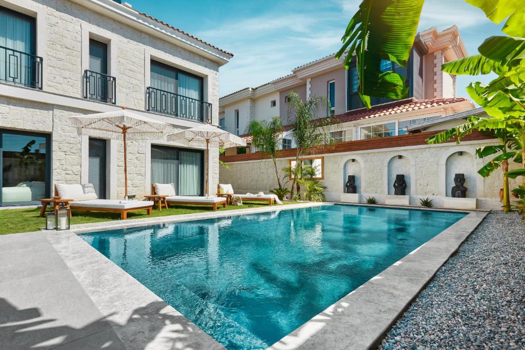 an image of a swimming pool in front of a house at Meruno Alaçatı in Çeşme