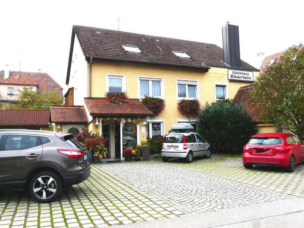 deux voitures garées devant une maison dans l'établissement Gästehaus Eberlein, à Rothenburg ob der Tauber