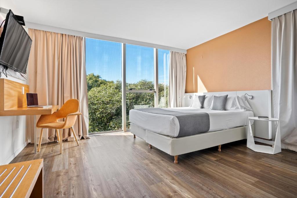 Cette chambre comprend un lit et une grande fenêtre. dans l'établissement Own Montevideo, à Montevideo