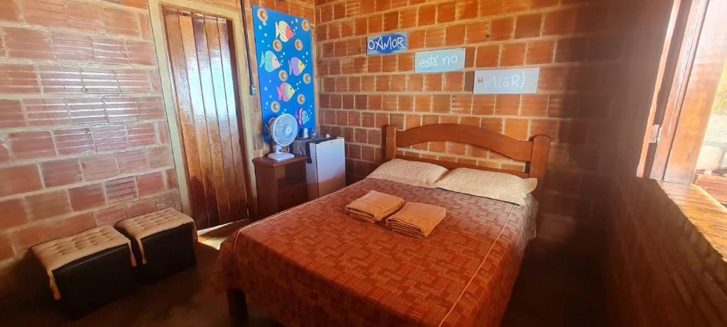 a bedroom with a bed in a brick wall at Suíte pé na areia in Icapuí