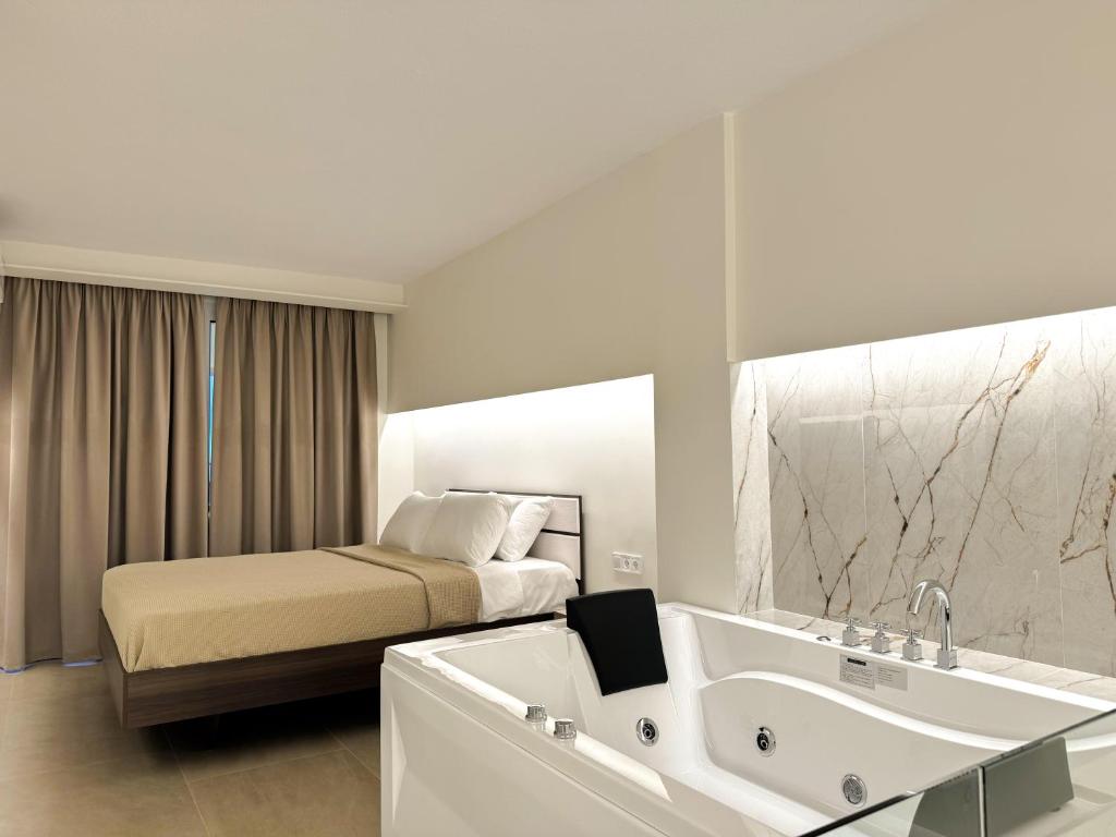 a hotel room with a bed and a bathtub and a sink at Eunoia Luxury Loft in Katerini