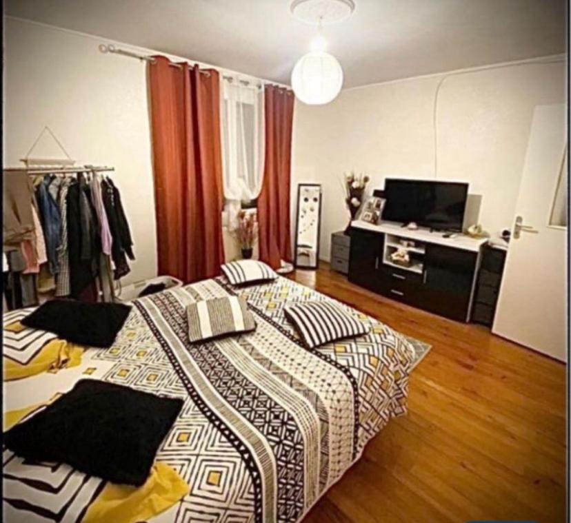 une chambre avec un lit avec une couette dessus dans l'établissement Chambre 2 personnes proche circuit 24h, au Mans