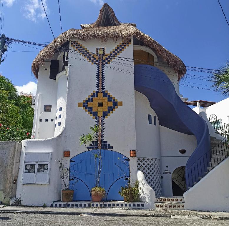 un edificio con una cruz pintada en el costado. en Amaranto Bed and Breakfast, en Cozumel