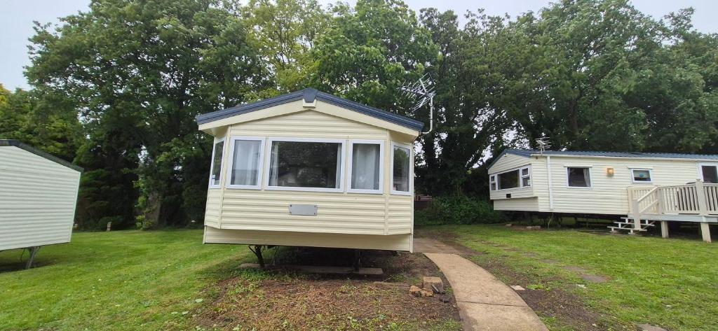 a tiny house sitting in the middle of a yard at Excellent Static Caravan in Shanklin