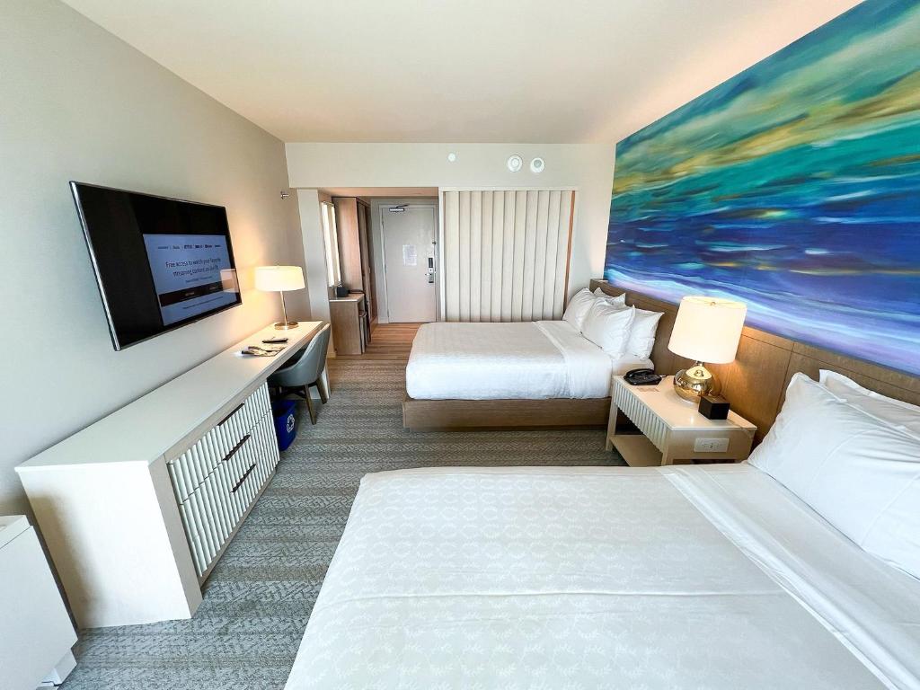 ein Hotelzimmer mit 2 Betten und einem Gemälde an der Wand in der Unterkunft Hotel Mars Meg at Delhi Airport in Neu-Delhi