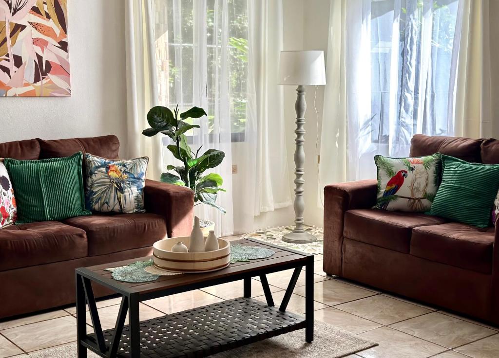 una sala de estar con 2 sofás marrones y una mesa. en Retiro Arenal, en Fortuna