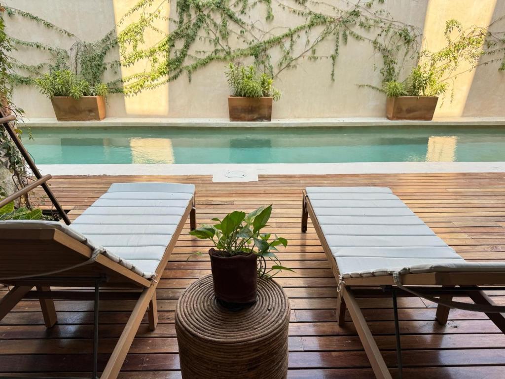 een patio met 2 stoelen en een zwembad bij Casa Ita Surf - Adults Only in Puerto Escondido
