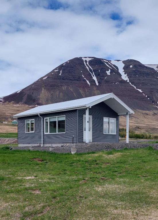 uma pequena casa em frente a uma montanha em Tungukot sumarhús em Akureyri