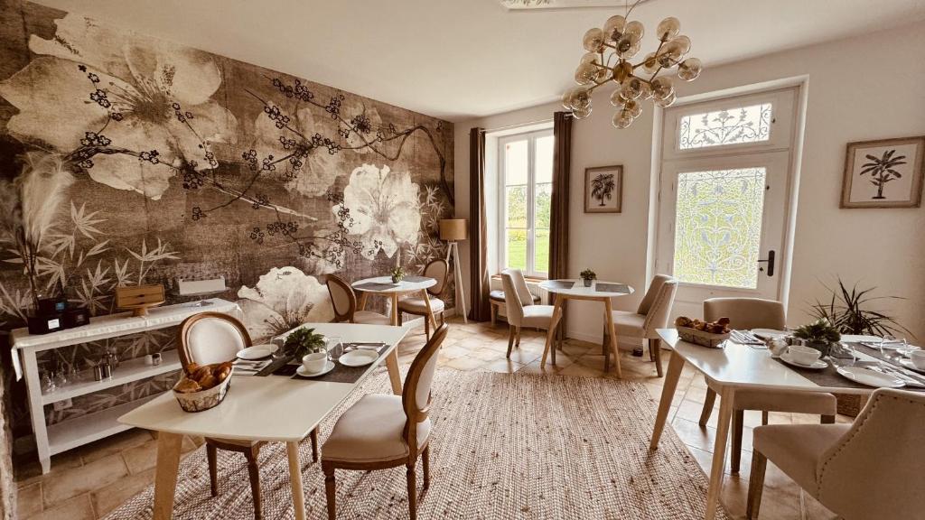 a dining room with tables and chairs and a painting on the wall at Aurefees in Ellon