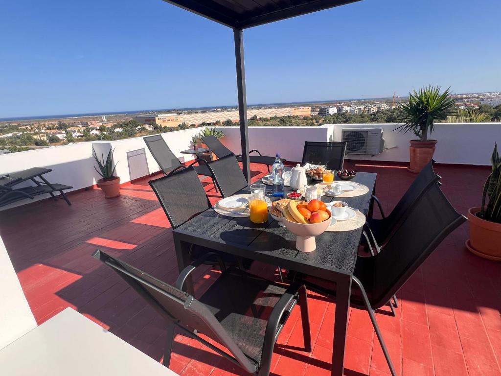 a table with a bowl of fruit on a balcony at Green Apartment in Tavira Garden in Tavira