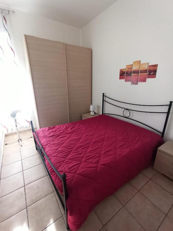 a bedroom with a bed with a red blanket at Casa del Papavero in Piombino