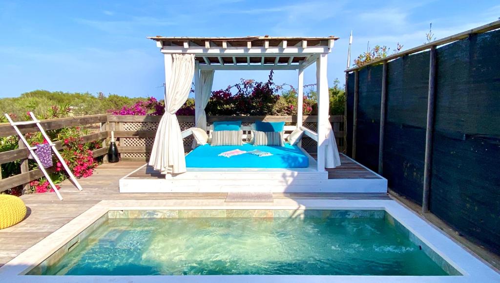 a bed in a gazebo next to a swimming pool at CAN DAMIA 2 in Cala Saona