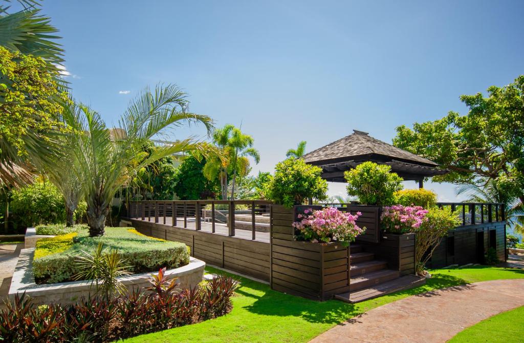 a garden with a wooden fence and flowers at Villa Gilgal in Kings Pen