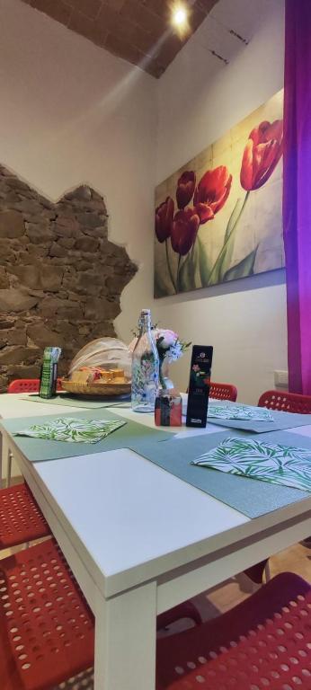 a table with red chairs and a painting on the wall at casa erica in Piombino