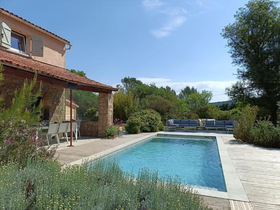 une piscine dans une cour à côté d'une maison dans l'établissement Villa de charme avec piscine en plein cœur du Var, à Rocbaron