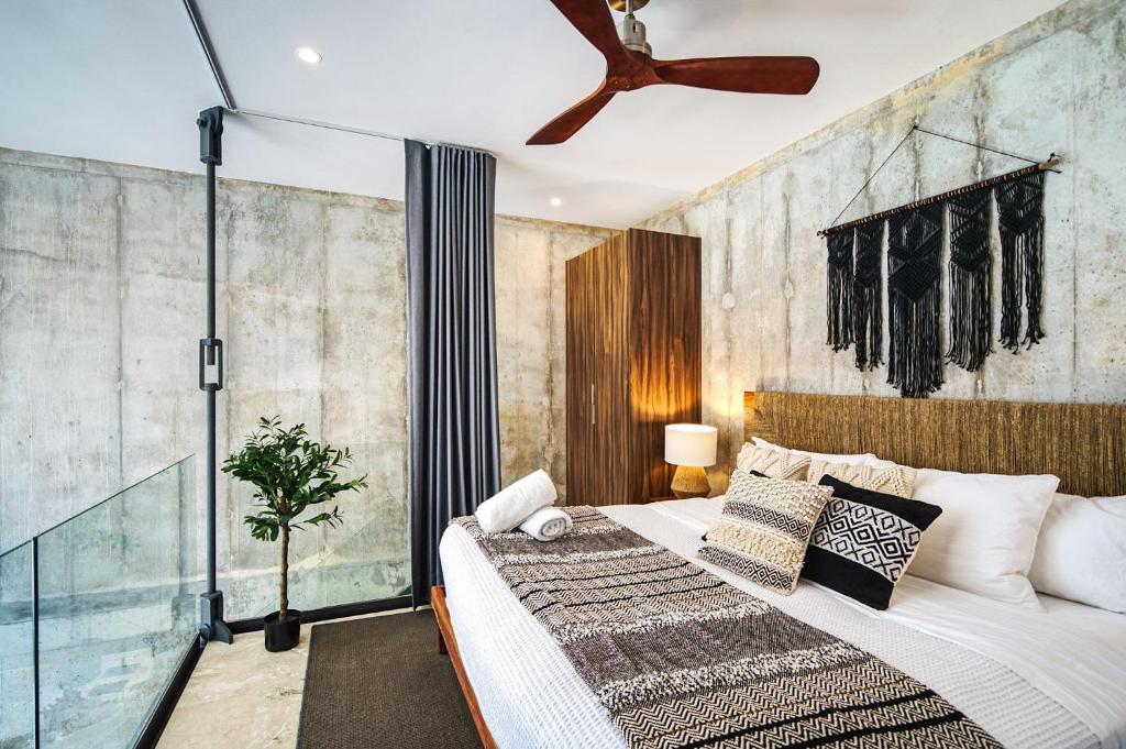 ein Schlafzimmer mit einem Bett und einer Glaswand in der Unterkunft Amazing 1BR Swim Up Cenote Gym in Tulum