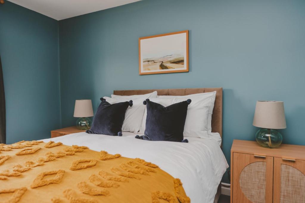 1 dormitorio con 1 cama grande y paredes azules en The Butterleigh Inn, en Cullompton
