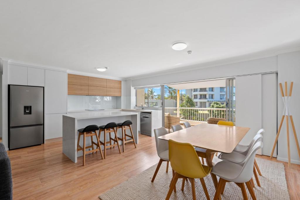 uma cozinha e sala de jantar com mesa e cadeiras em Narrowneck Court Holiday Apartments em Gold Coast