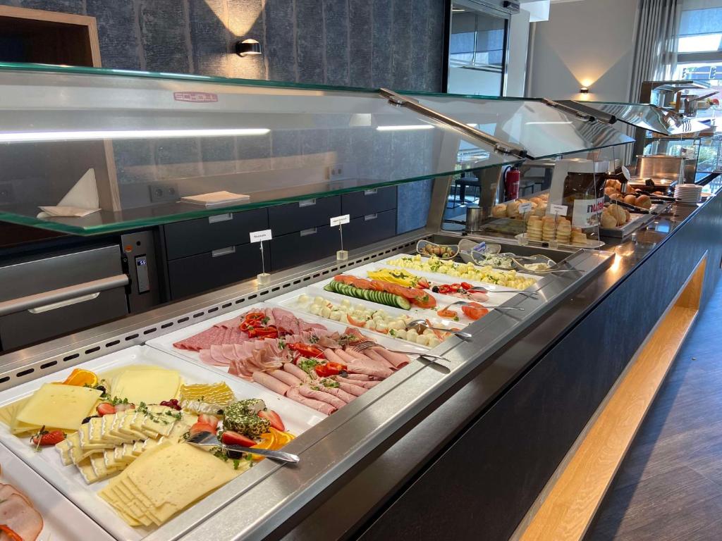een buffet lijn met veel verschillende soorten eten bij Median Hotel Hannover Lehrte in Lehrte