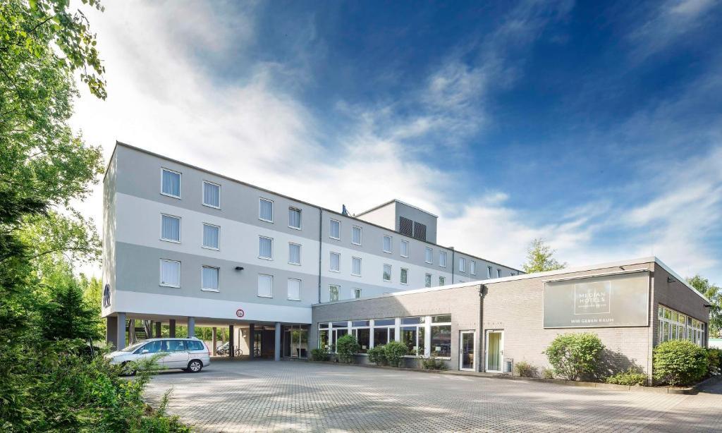 a building with a car parked in front of it at Median Hotel Hannover Messe in Hannover
