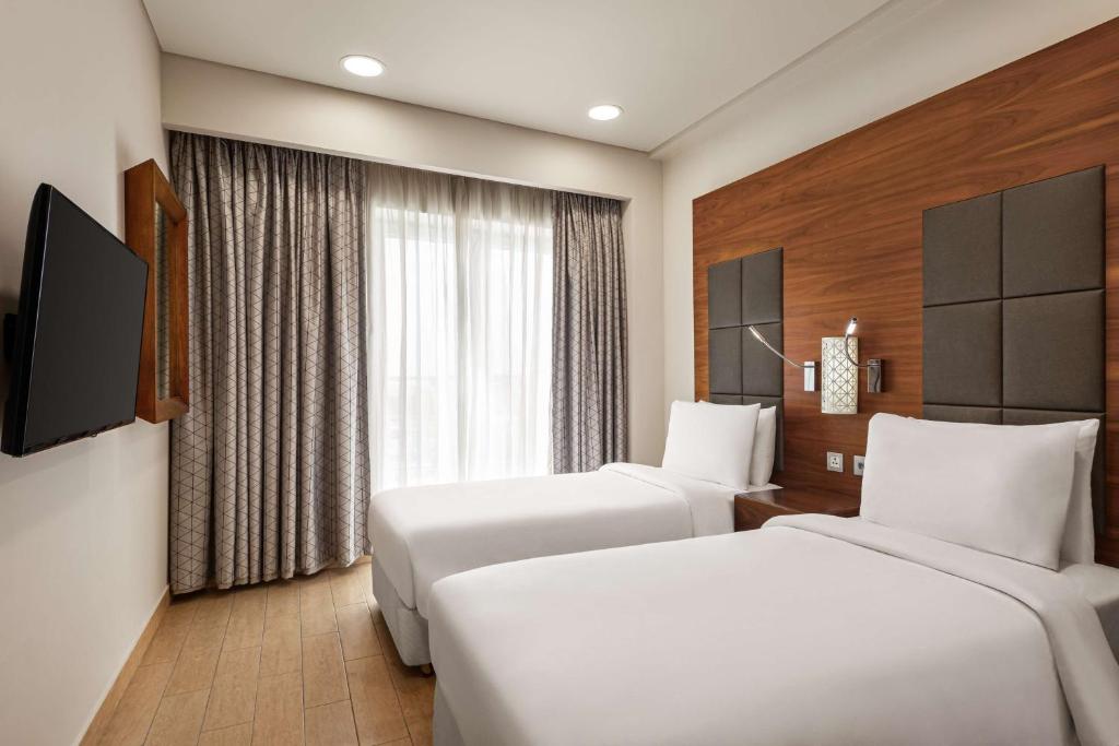 Postel nebo postele na pokoji v ubytování Levatio Suites Muscat, a member of Radisson Individuals