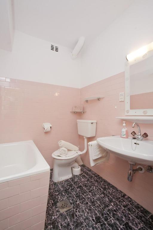 ein Badezimmer mit einem weißen WC und einem Waschbecken in der Unterkunft St. Oswalderhof in Pörtschach am Wörthersee