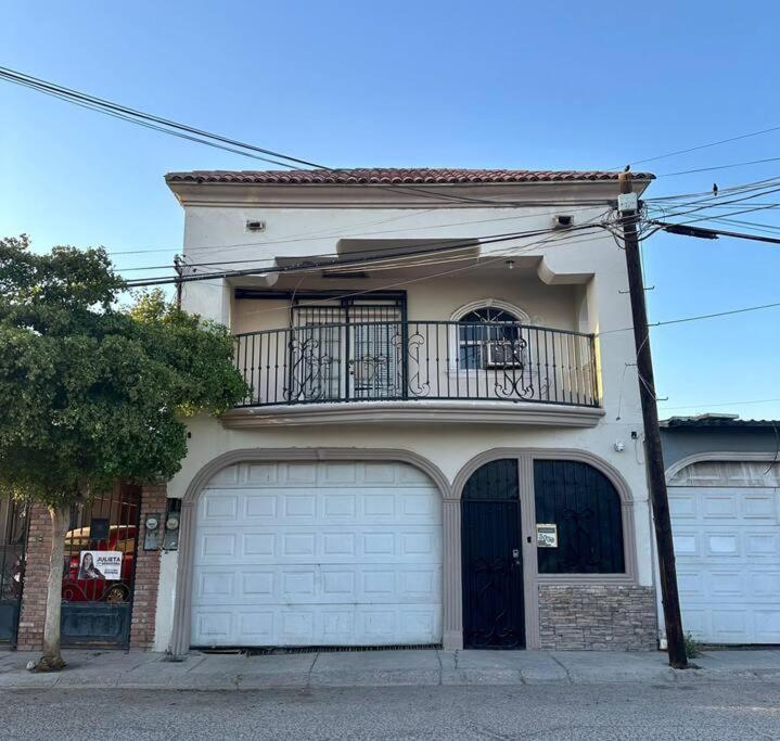 een huis met twee garagedeuren en een balkon bij Casa en Mexicali in Mexicali