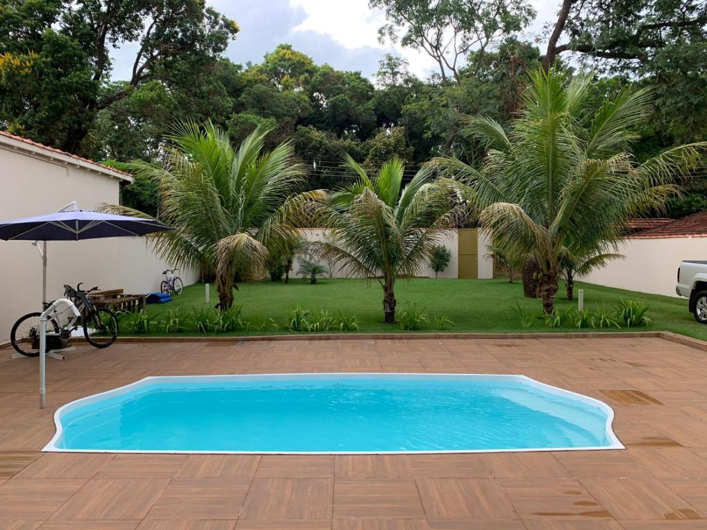 Itaí的住宿－Rancho Costa Azul Avaré，棕榈树庭院中的蓝色游泳池