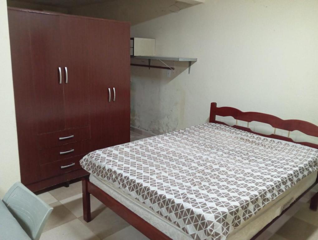 ein Schlafzimmer mit einem Bett, einem Schrank und einem Stuhl in der Unterkunft Casa Bela Vista in Socorro