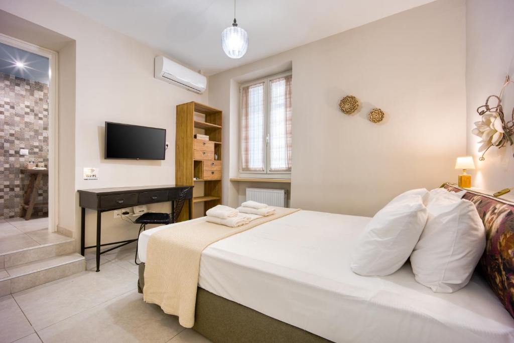 sypialnia z łóżkiem, biurkiem i telewizorem w obiekcie Pagrati/Hilton area, Bentzi (3) Boutique Apt. for 4 w Atenach