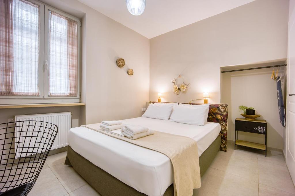 sypialnia z dużym białym łóżkiem i oknem w obiekcie Pagrati/Hilton area, Bentzi (3) Boutique Apt. for 4 w Atenach