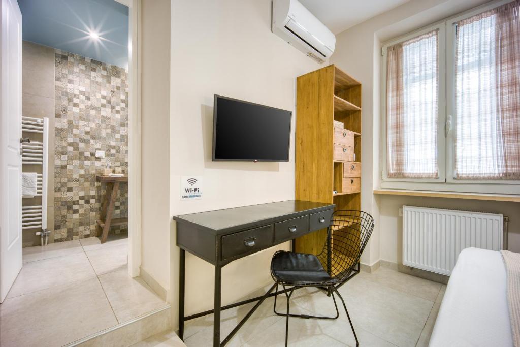 sypialnia z biurkiem i telewizorem na ścianie w obiekcie Pagrati/Hilton area, Bentzi (3) Boutique Apt. for 4 w Atenach