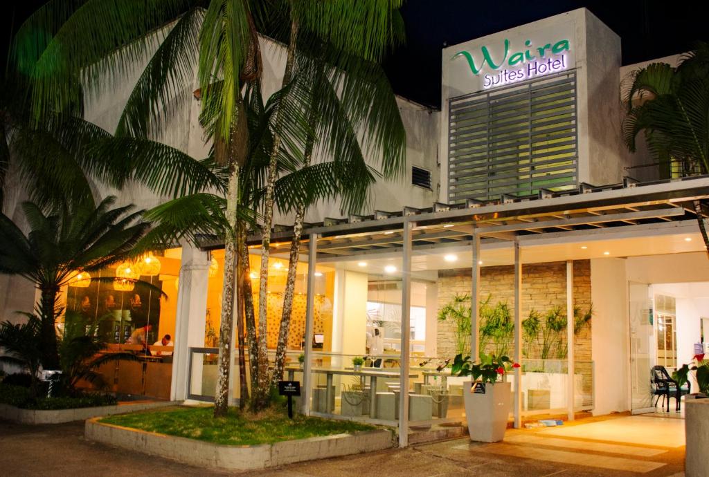 a store front with palm trees in front of it at Waira Suites in Leticia