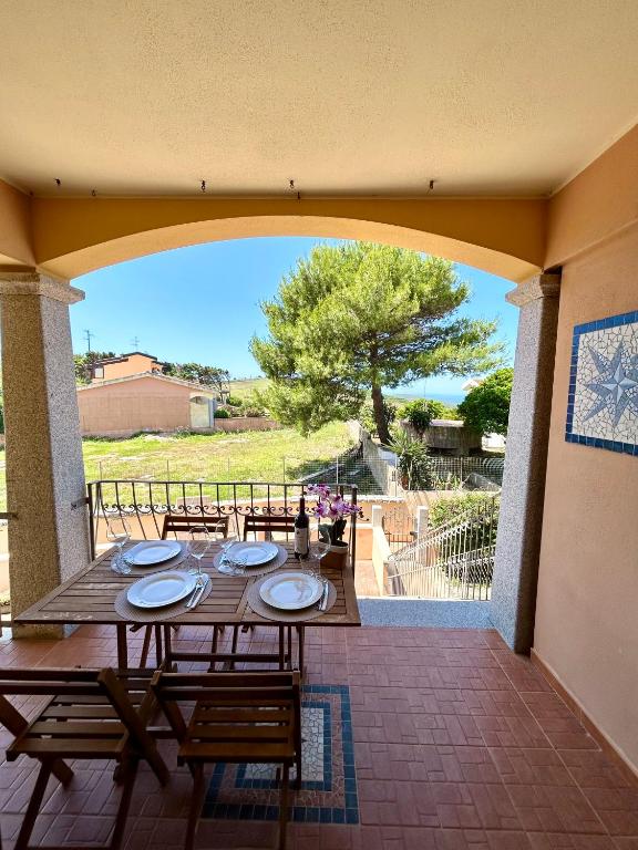 a table and chairs on a patio with a view at Il tramonto tra Alghero e Stintino in Palmadula