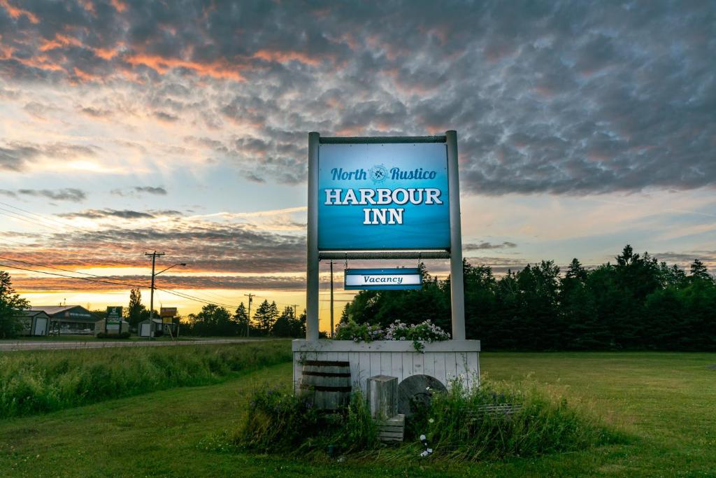 a sign for a harcourt inn in a field at North Rustico Harbour Inn in North Rustico