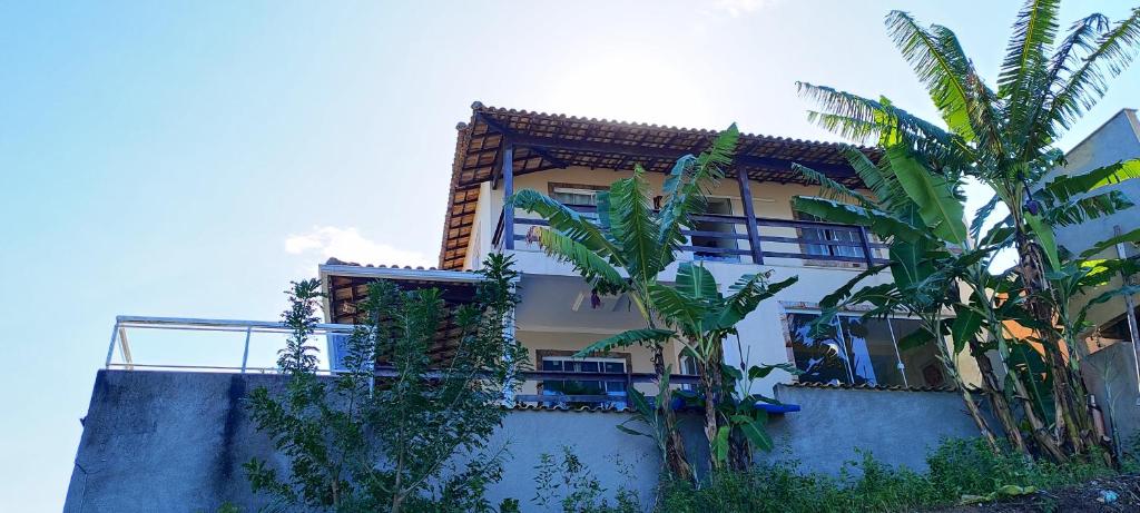 un bâtiment avec des palmiers devant dans l'établissement Cantinho do paraíso da Deuza, à São Pedro da Aldeia