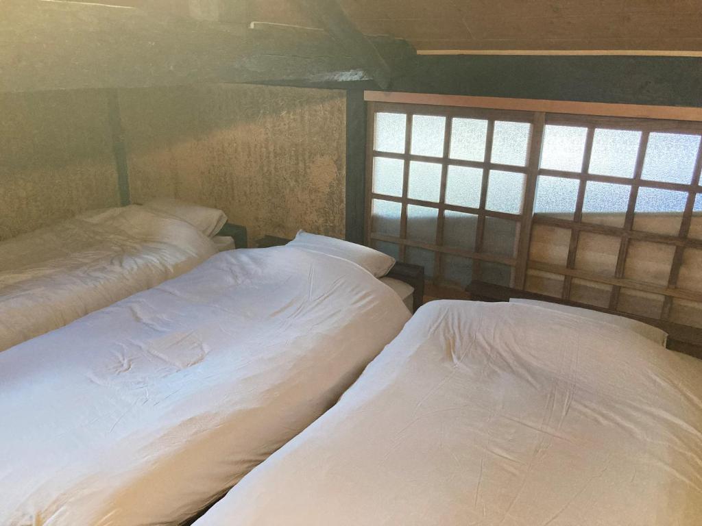Postel nebo postele na pokoji v ubytování 出雲古民家の宿maemori