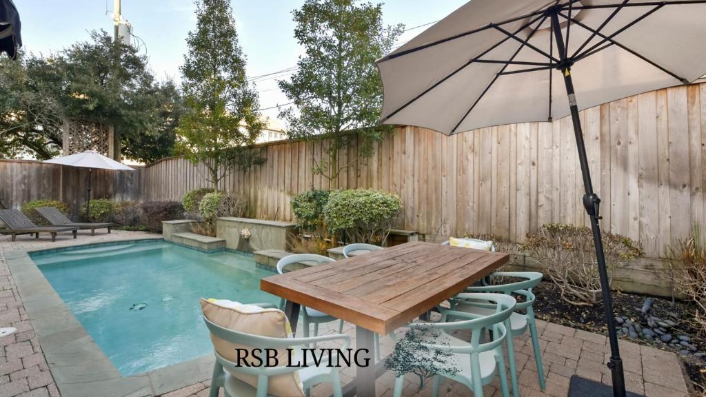 a patio table with an umbrella next to a pool at Cozy and Roomy Home with Private Pool in Houston