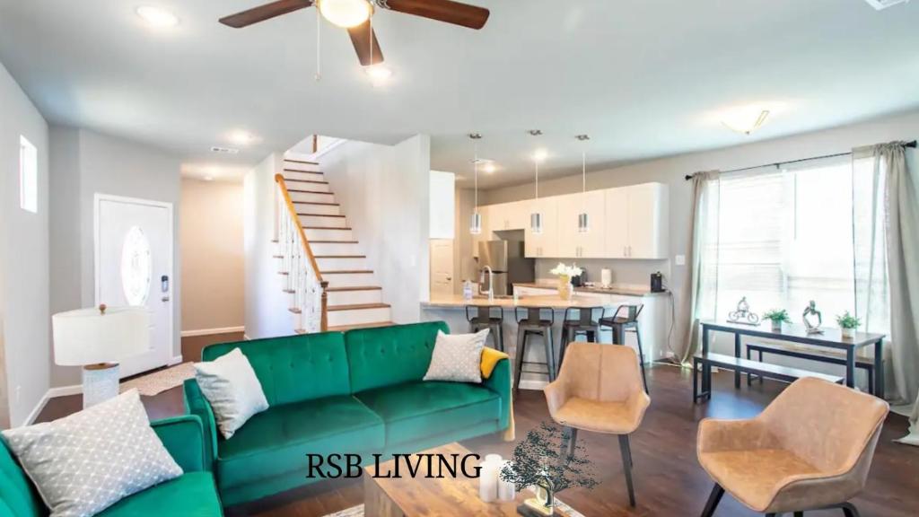 a living room with a green couch and a kitchen at 4BR 2,5BA Holiday Home in the Heart of Cowboy Nation in Arlington