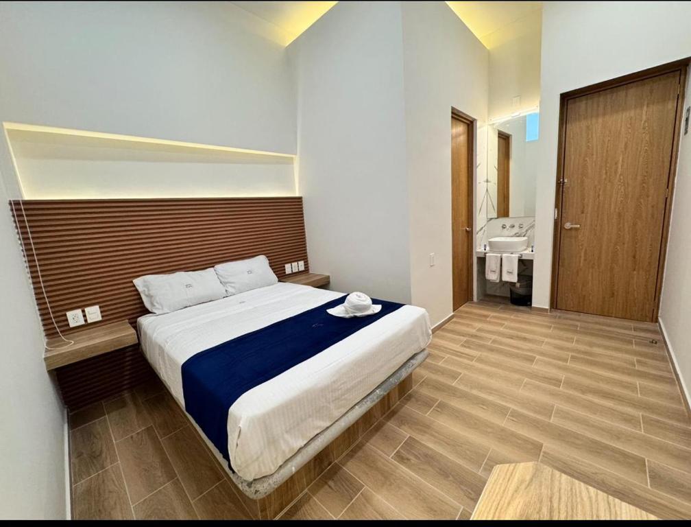a bedroom with a large bed and a bathroom at Hotel Kapu in Puebla